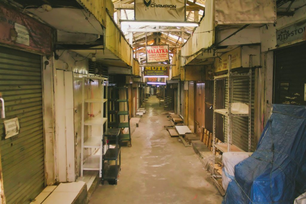 An empty, narrow alleyway lined with closed shops.